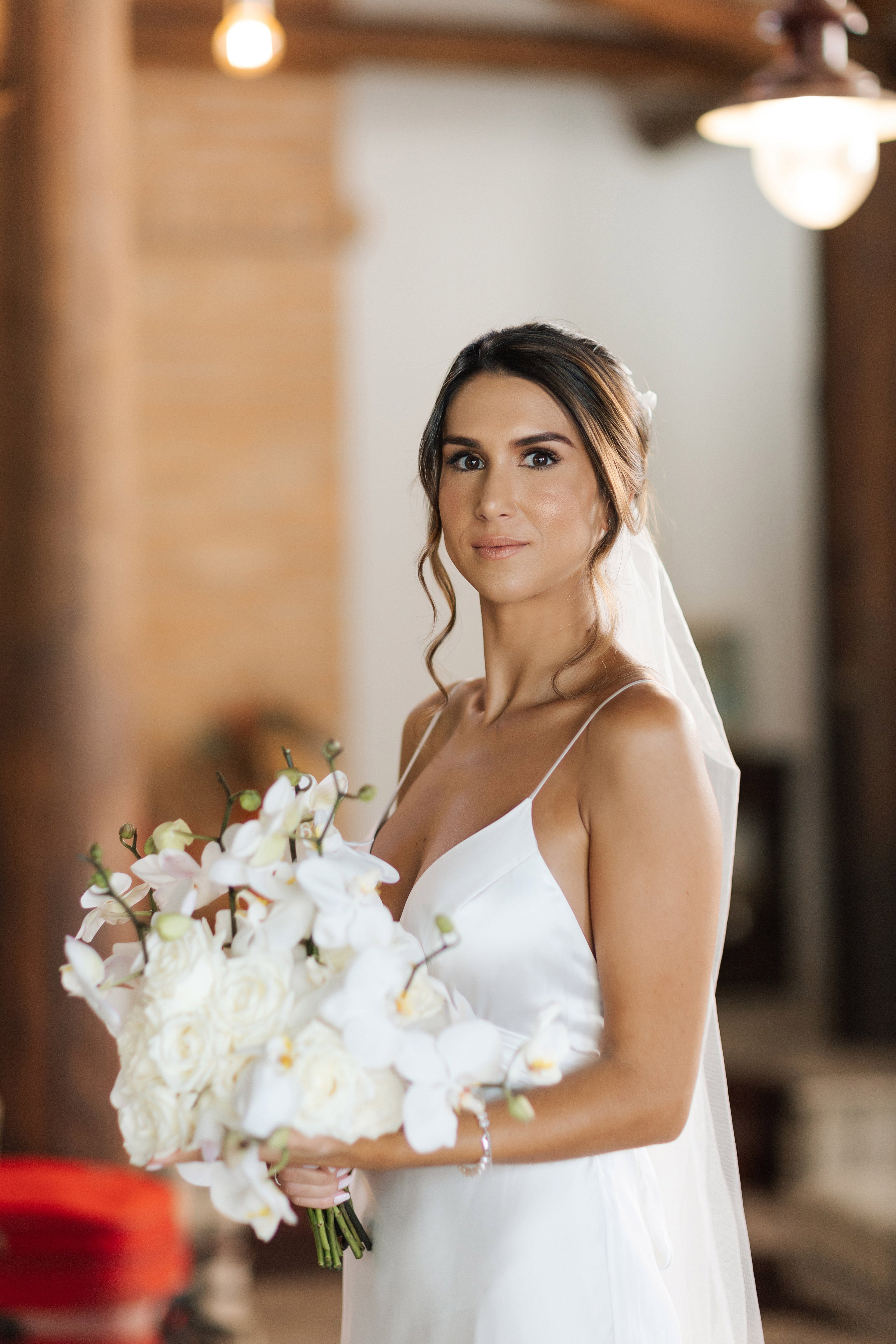 Beautiful bride in white wedding dress holding a bouquet of flowers