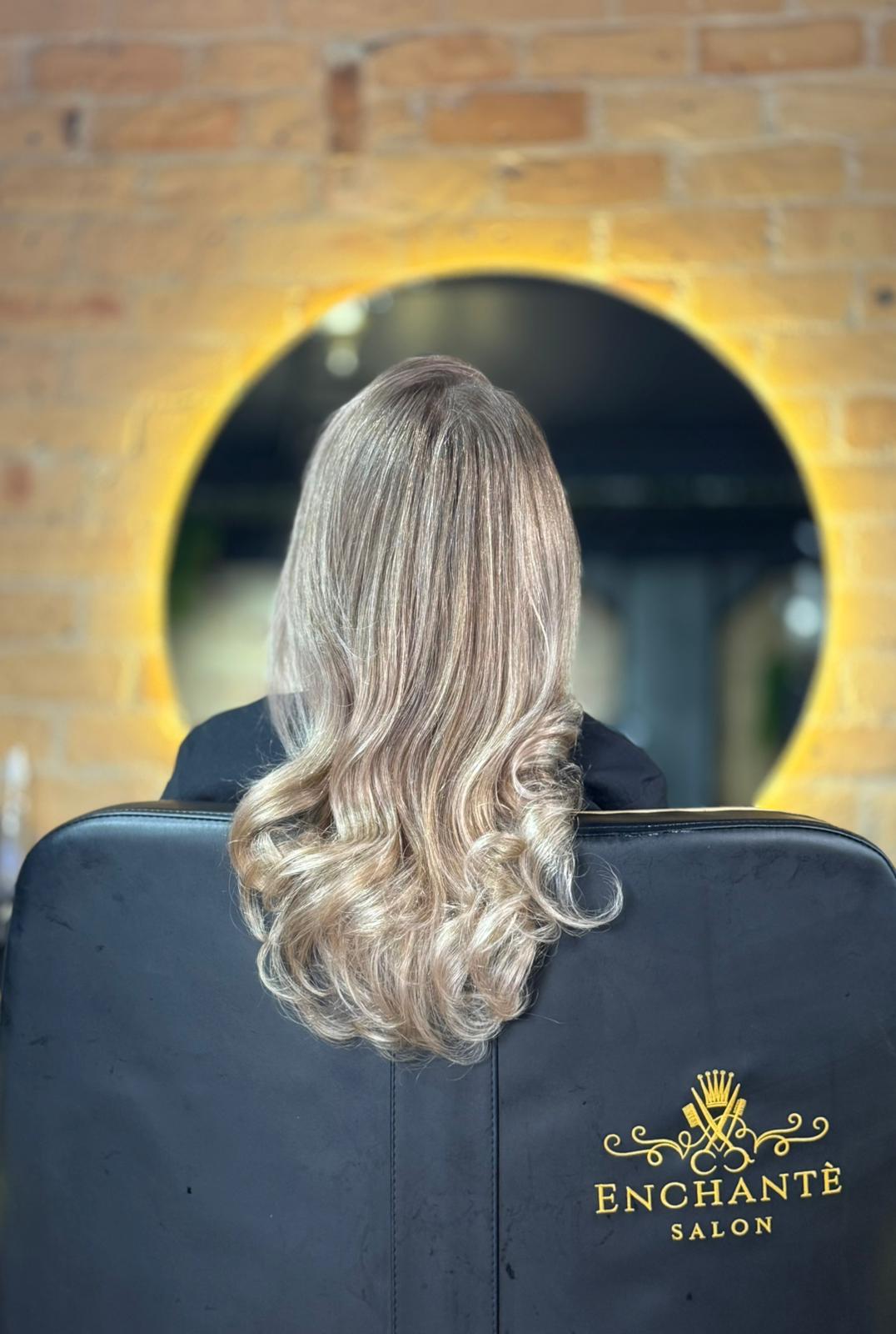 Professional hairstylist styling a woman's hair in an elegant updo